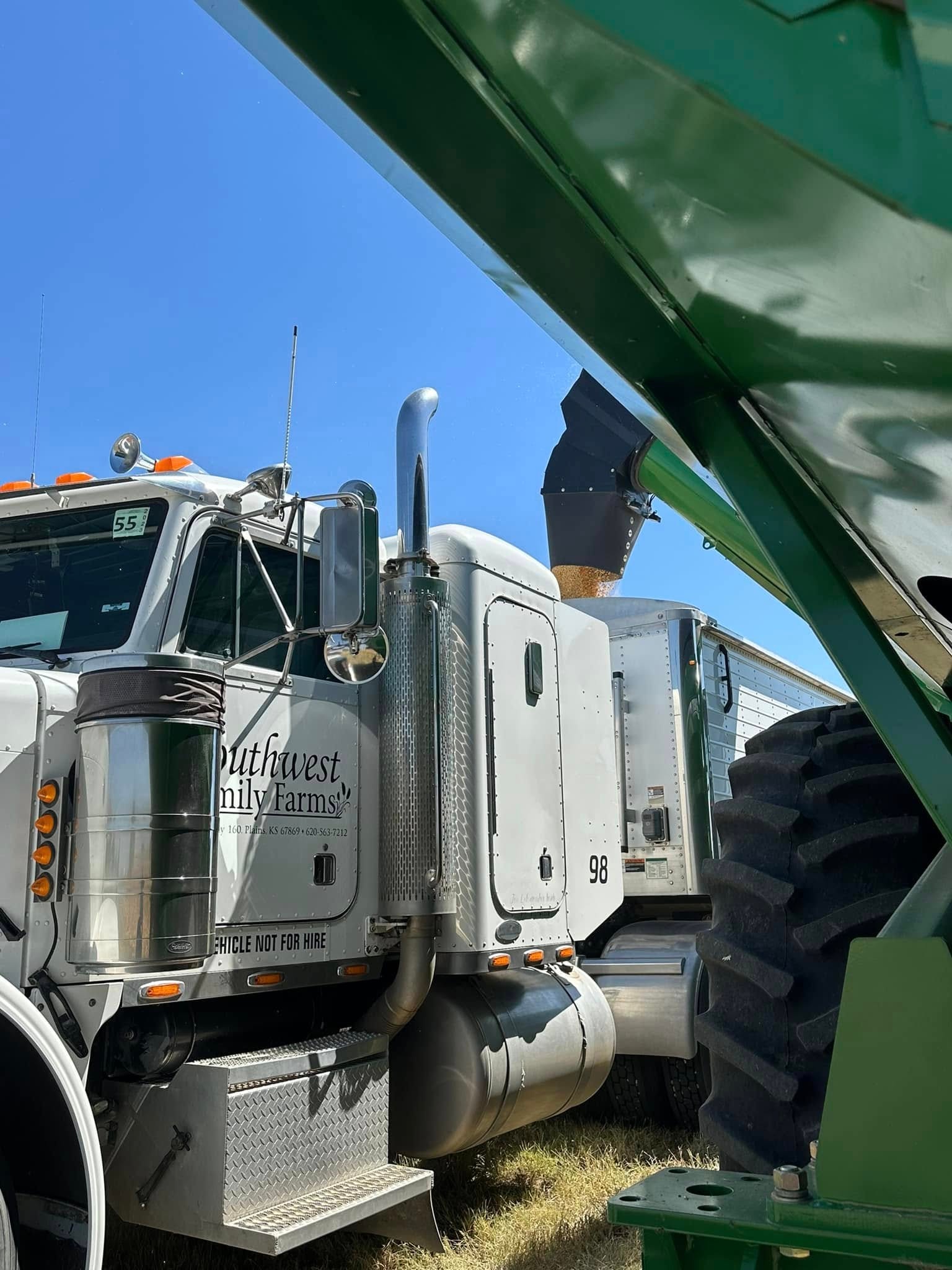 Southwest Family Farms semi truck loading grain from a combine