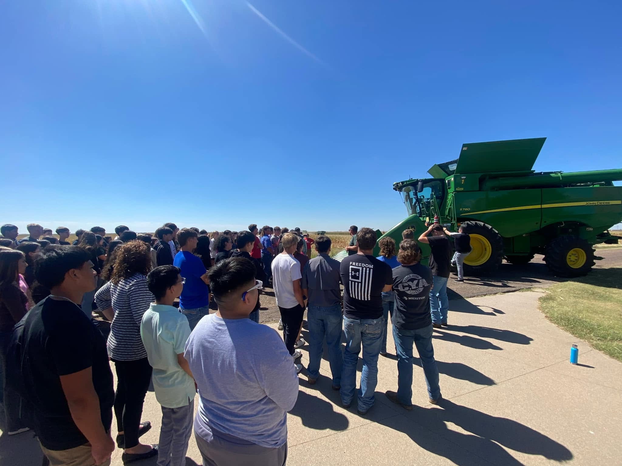 Students gathered around a John Deere combine at a foundation event