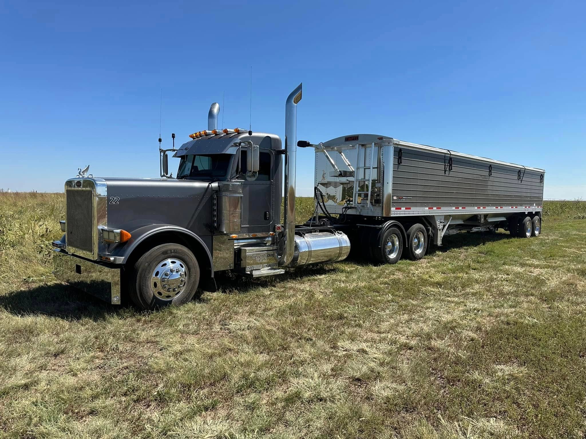Semi truck with grain trailer parked in a field